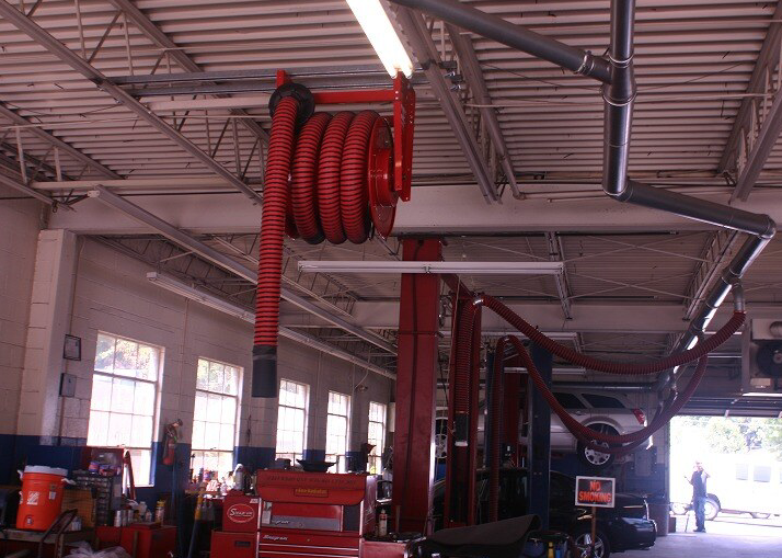 Hose reel shown installed in a vehicle repair shop.