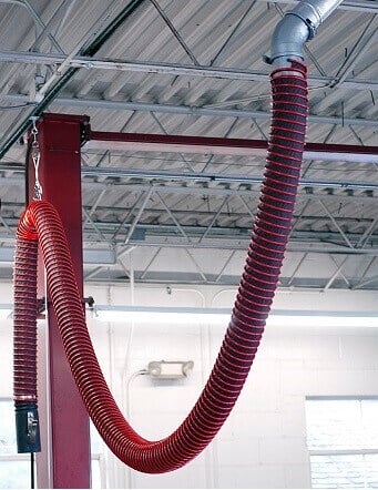 Vehicle exhaust hose installed in an auto repair shop for safe and compliant emissions removal.