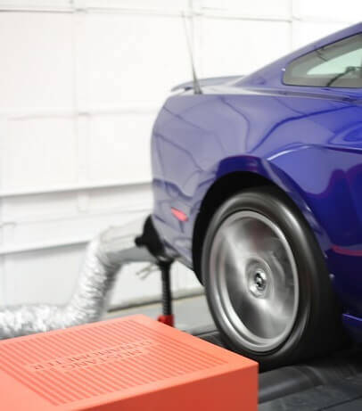 Fume-A-Vent dynamometer exhaust removal system capturing harmful emissions in a vehicle performance testing facility